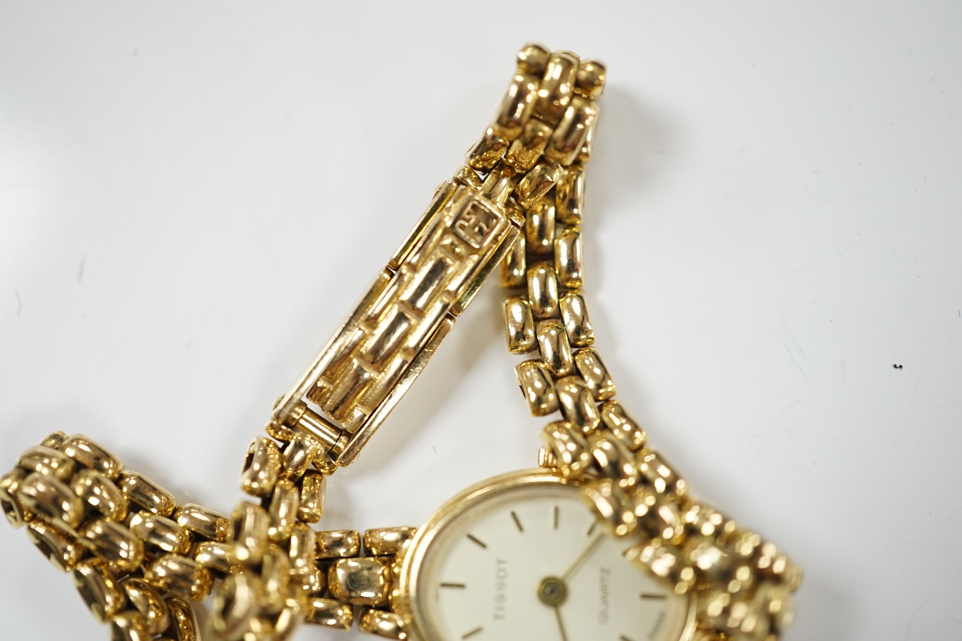 A lady's modern 9ct gold Tissot quartz wrist watch, on a 9ct gold bracelet, gross weight 19.5 grams. Condition - poor to fair